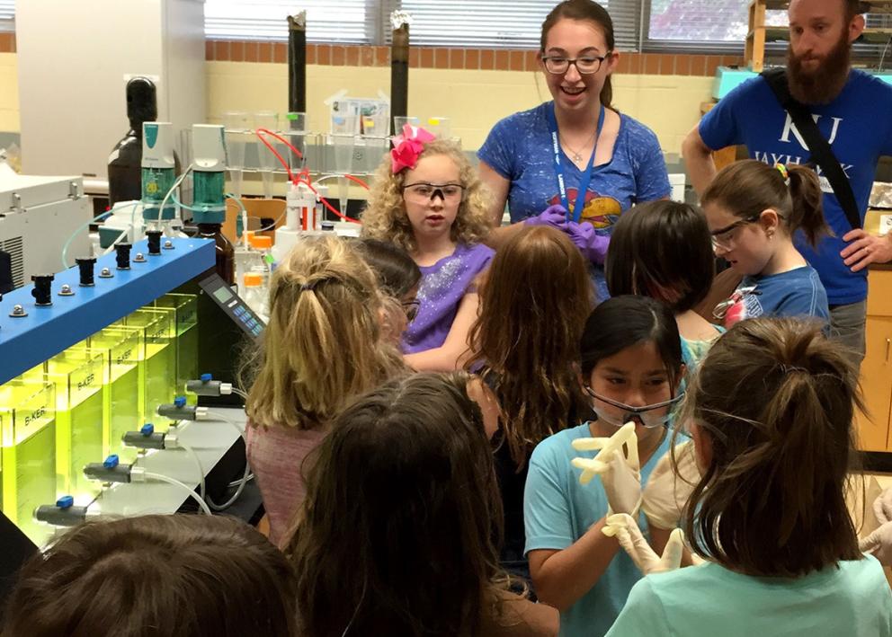 Girl scouts huddled around a water testing machine